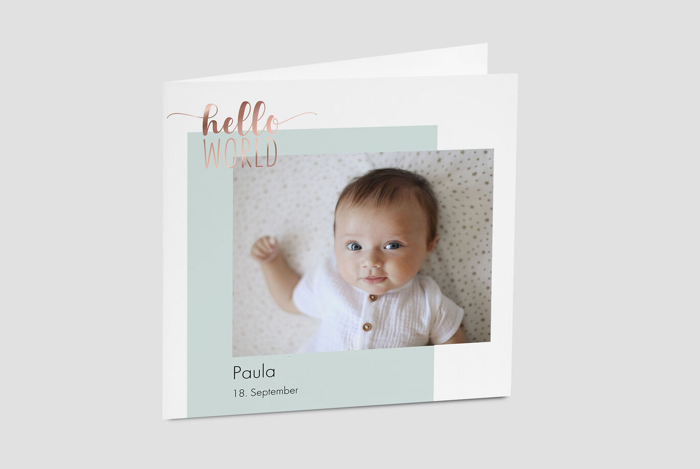 Ein liebevoll gestaltetes CEWE Grußkarten-Design mit einem Foto von einem Baby. Text: "Hallo Welt" und der Name "Paula".