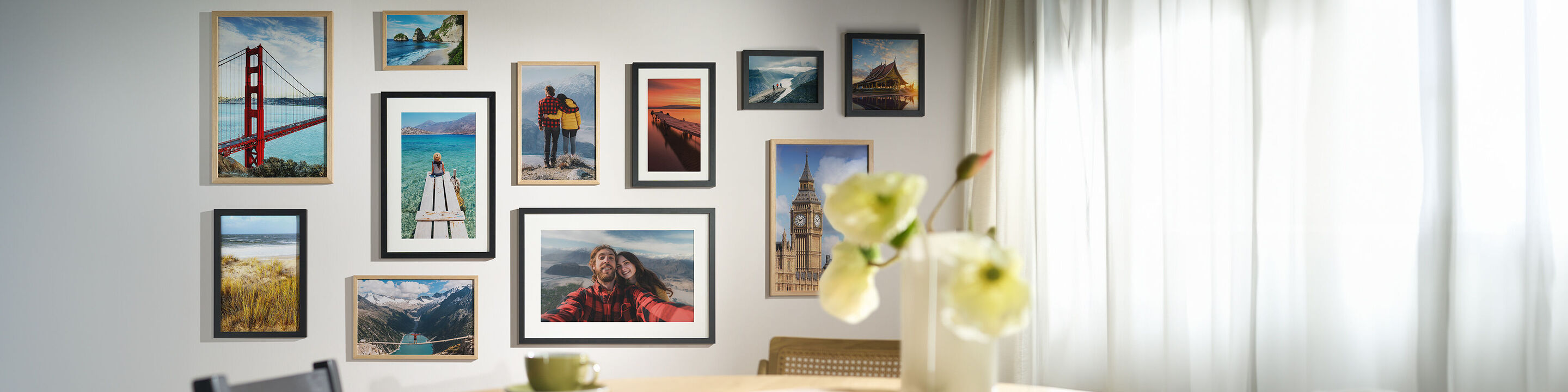 Verschiedene CEWE Wandbilder mit Reise- und Landschaftsmotiven in Bilderrahmen an einer Wohnzimmerwand