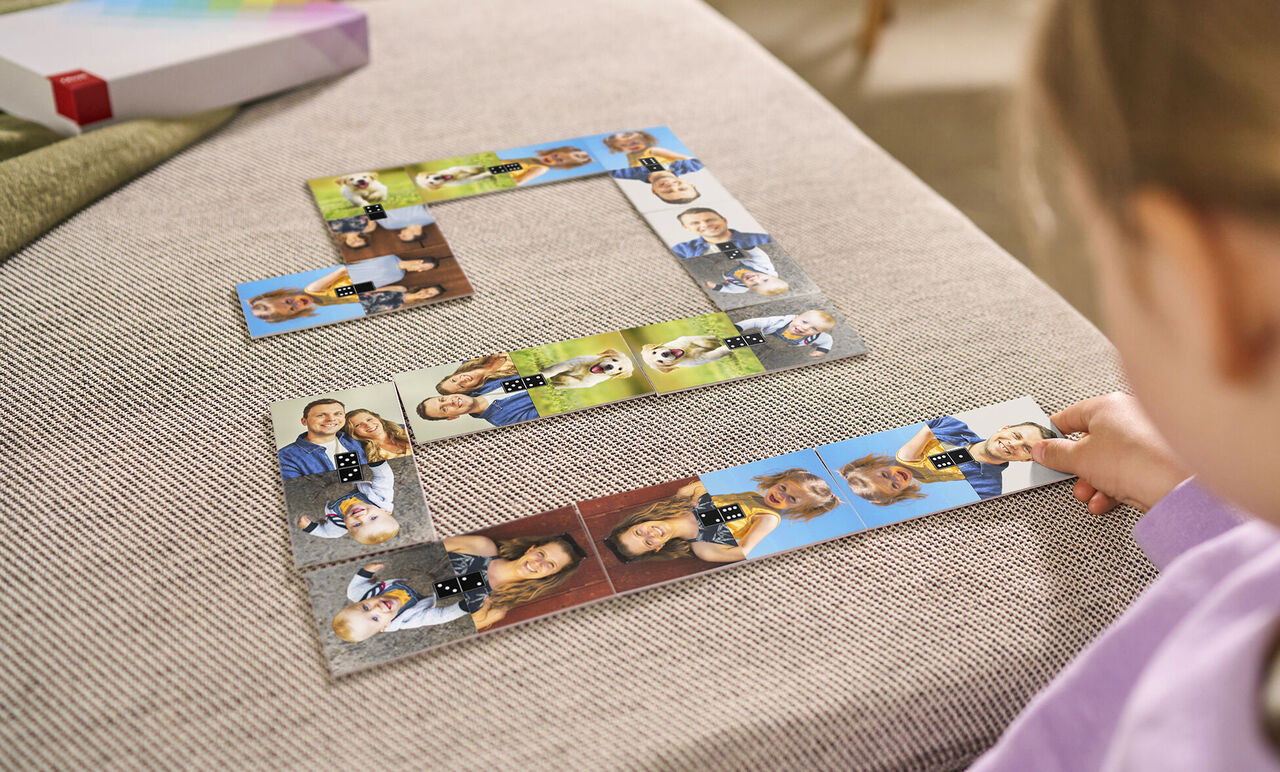 Ein Kind spielt mit einem Fotopuzzle, das verschiedene persönliche Fotos zeigt