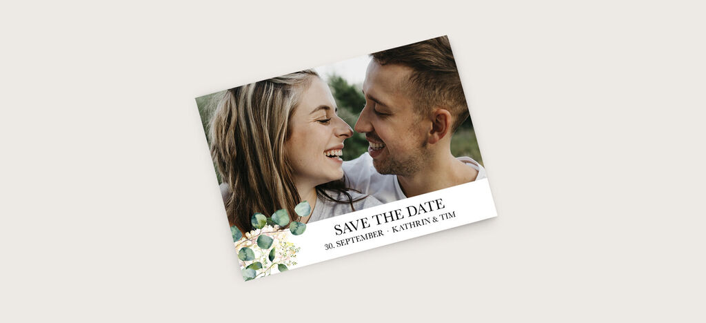 Paar auf einer Save-the-Date-Karte, umgeben von floralen Elementen