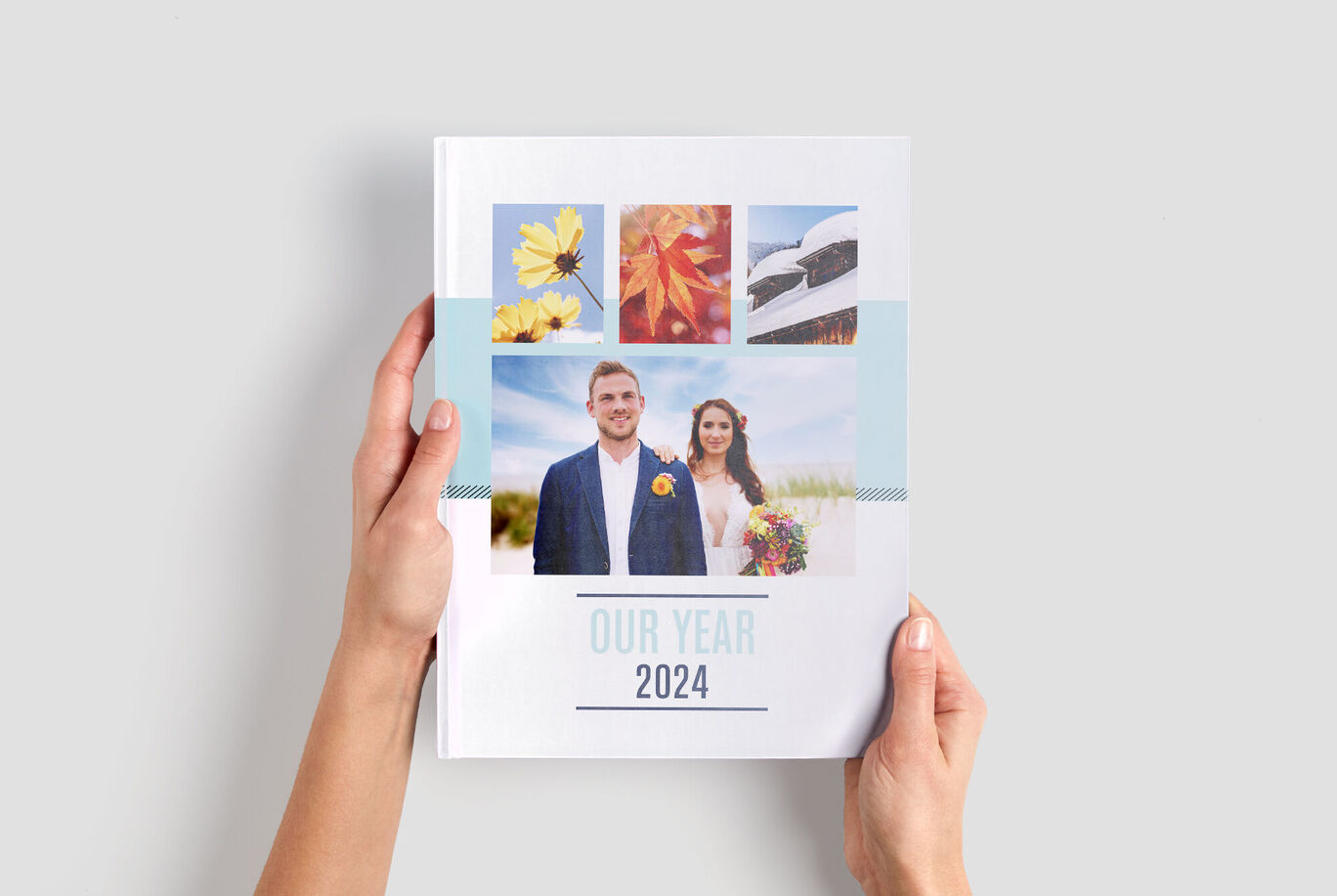Ein paar zeigt stolz ihr CEWE Fotobuch "Unser Jahr 2024" mit bunten Motiven.