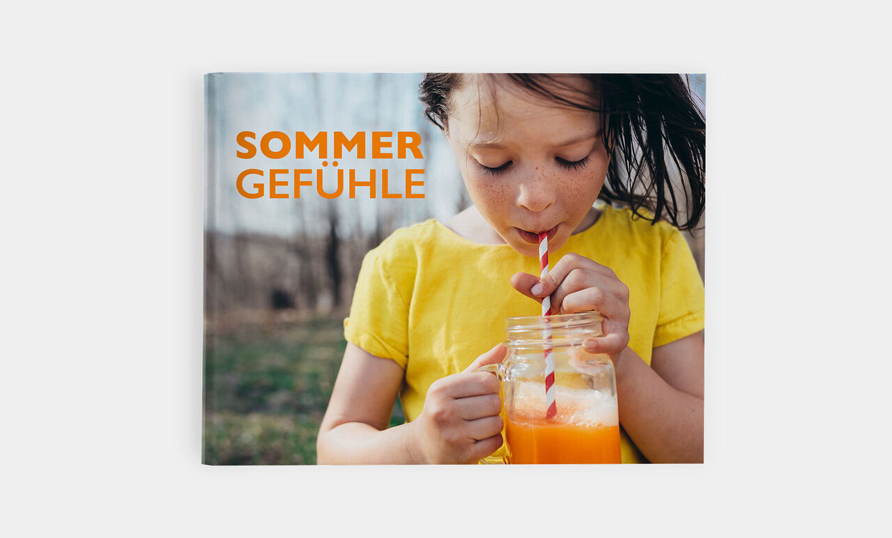 Ein Kind mit einem Glas Saft an einem sonnigen Tag