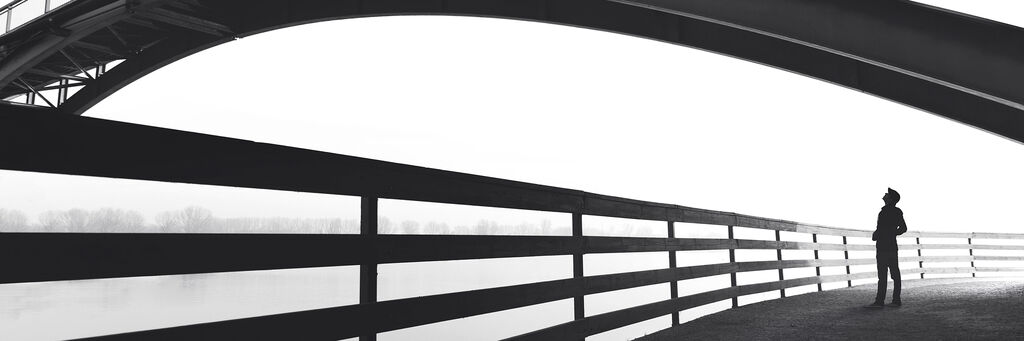 Silhouette eines Menschen vor einer großen Brücke, ruhige Atmosphäre