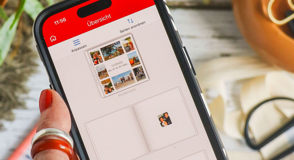Handy zeigt Übersicht eines CEWE Fotobuchs mit verschiedenen Bildern