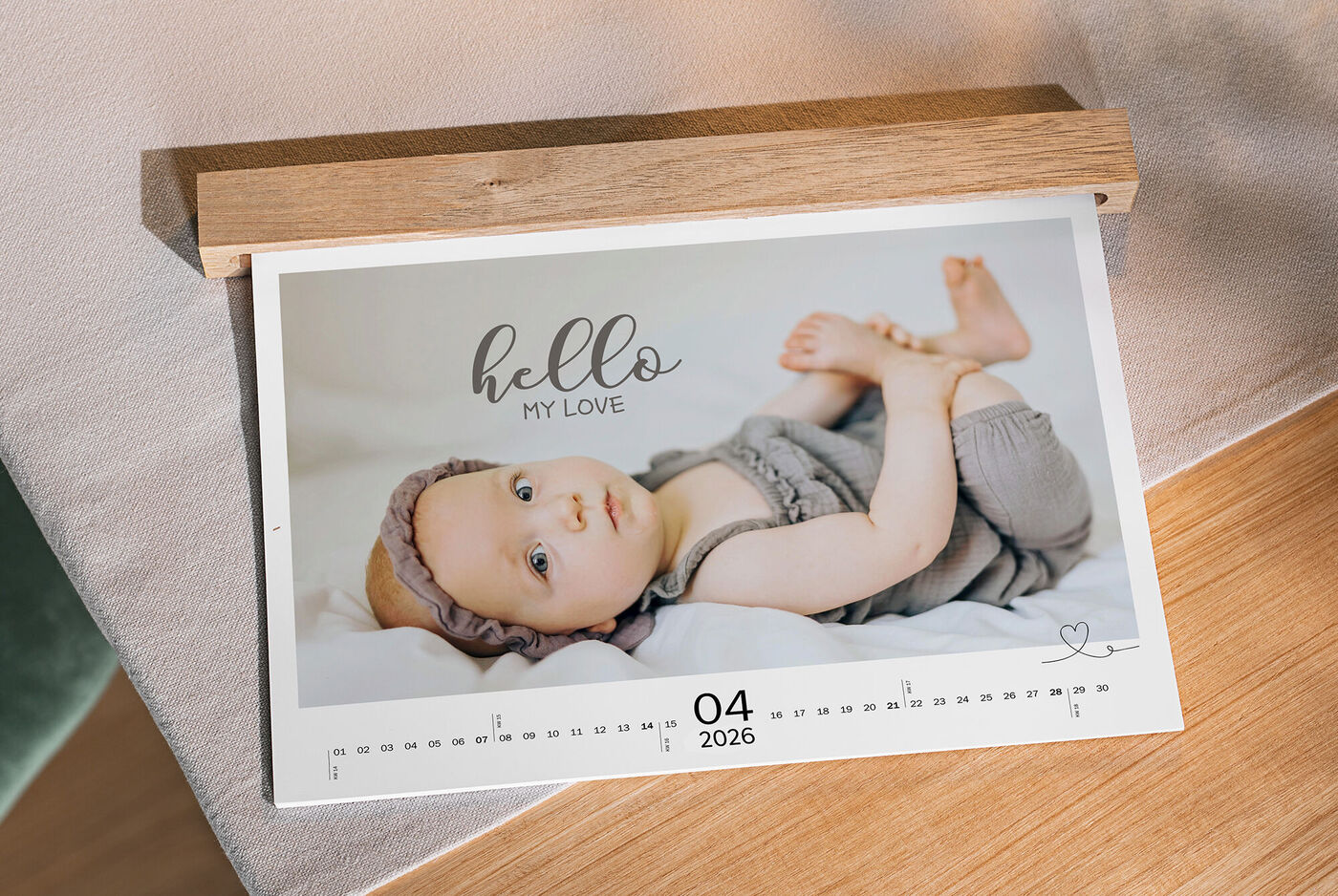 Ein schöner Fotokalender mit einem schlafenden Baby in einem grauen Outfit. Der Text oben sagt: 'hello MY LOVE'.