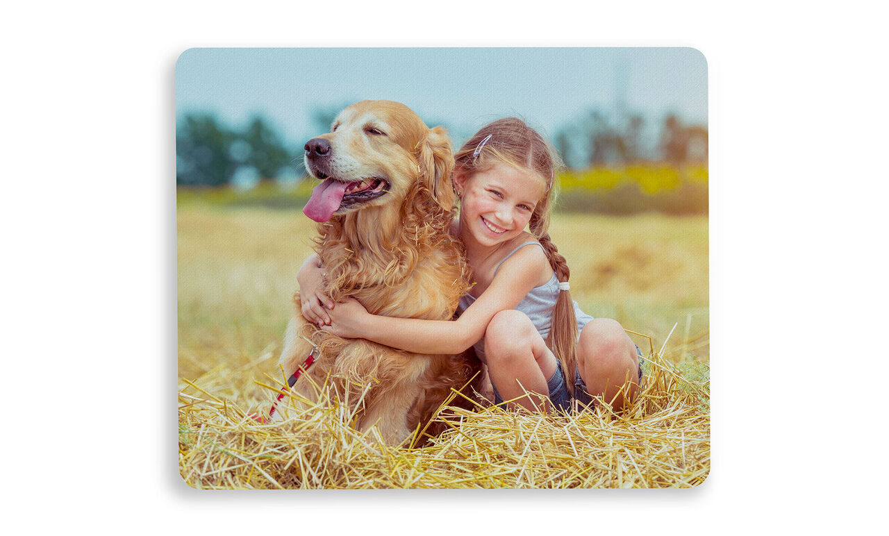Ein Kind umarmt einen goldenen Retriever auf einer schönen Wiese.