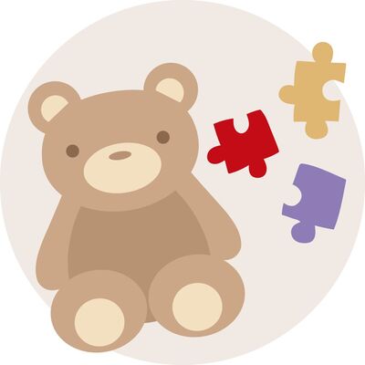 Ein niedlicher, brauner Teddy mit bunten Puzzlestücken daneben