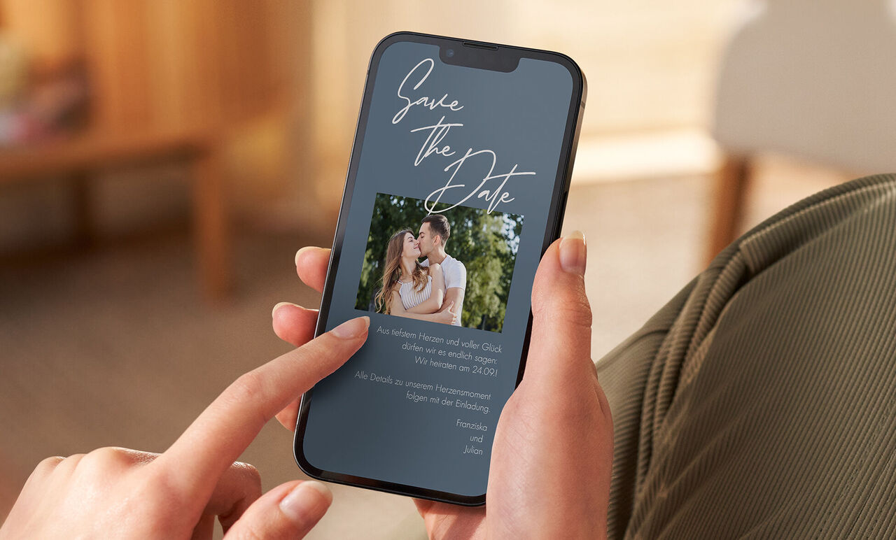 Eine digitale Save the Date Karte in einem dunkelblauen Design mit einer Fotofläche auf einem Handybildschirm.