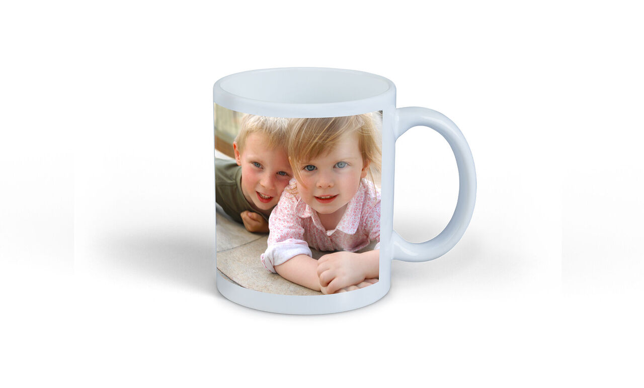 Eine Tasse mit einem liebevollen Foto von zwei kleinen Kindern, die lächeln und zusammen spielen