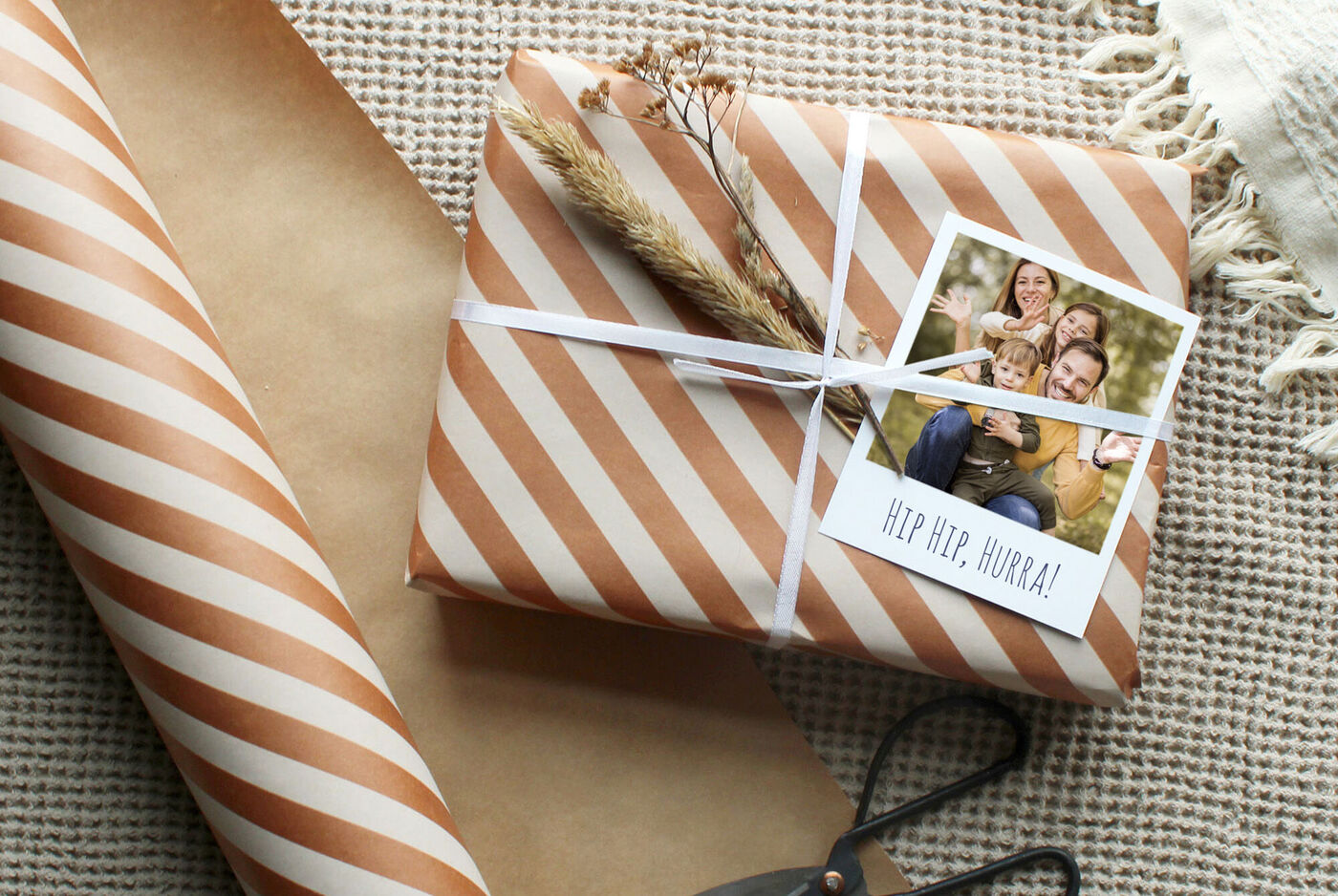 Ein hübsch verpacktes Geschenk mit Braun-weißem Papier und einer persönlichen Foto-Grußkarte