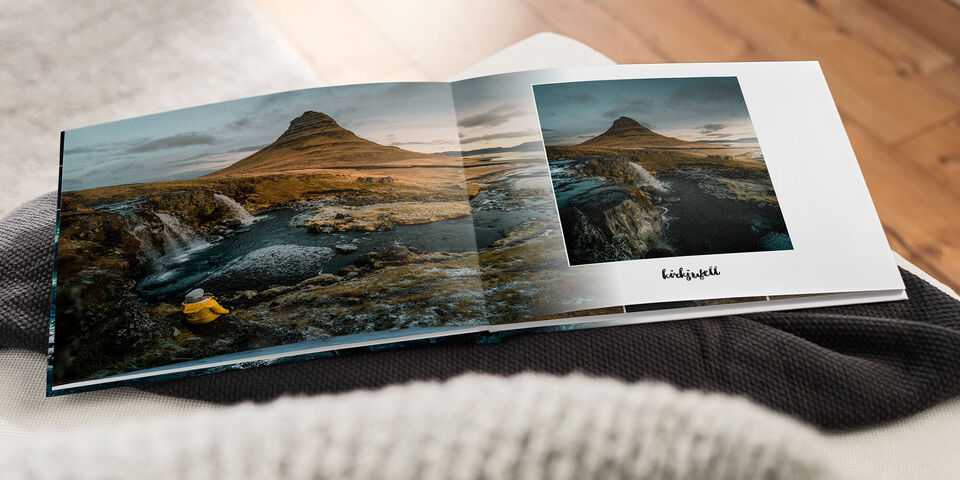 Ein geöffnetes CEWE Fotobuch mit Bildern einer bergigen Landschaft und einem Fluss.