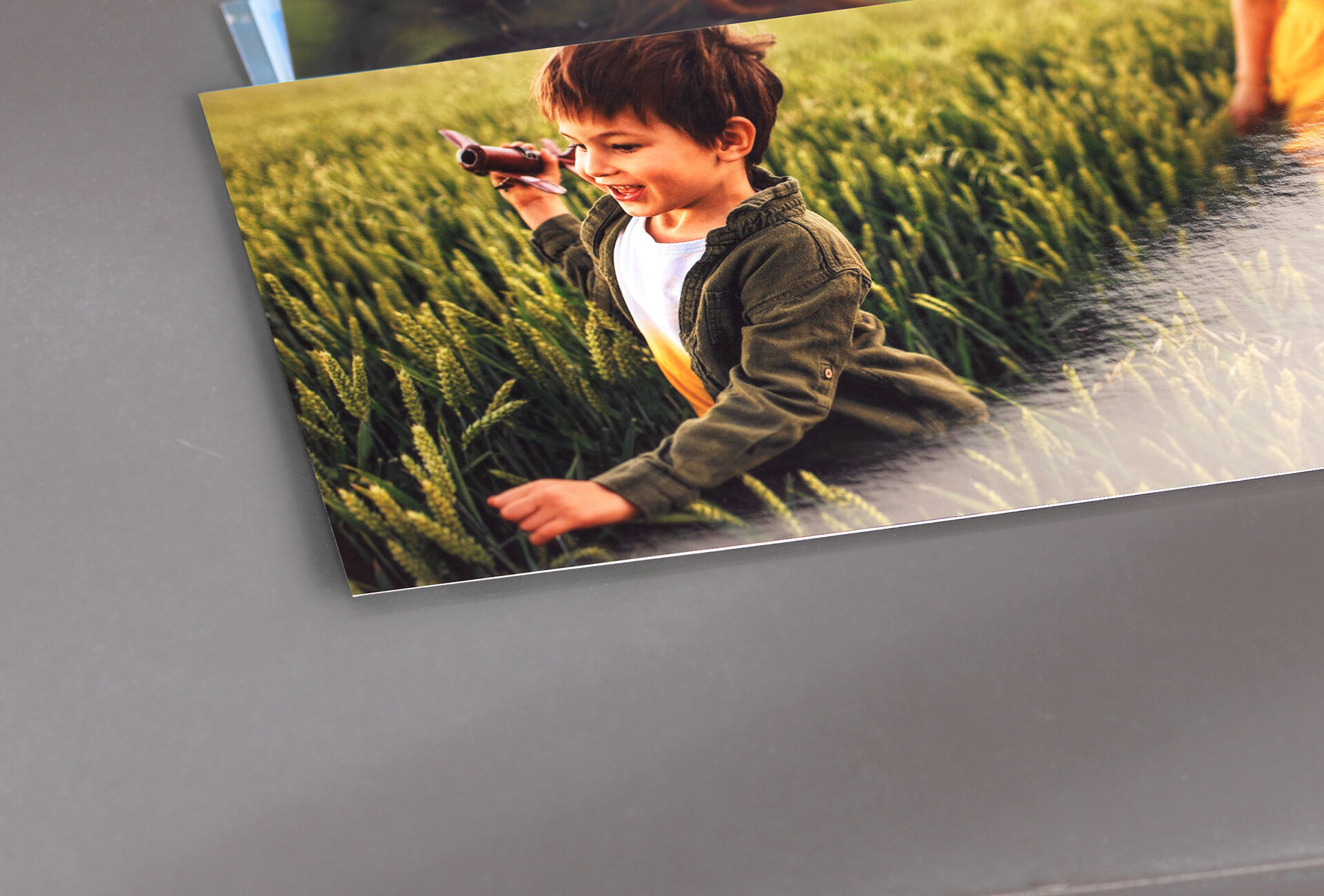 Ein Kind in einem Feld, das mit einer Spielzeugkamera nach etwas sucht