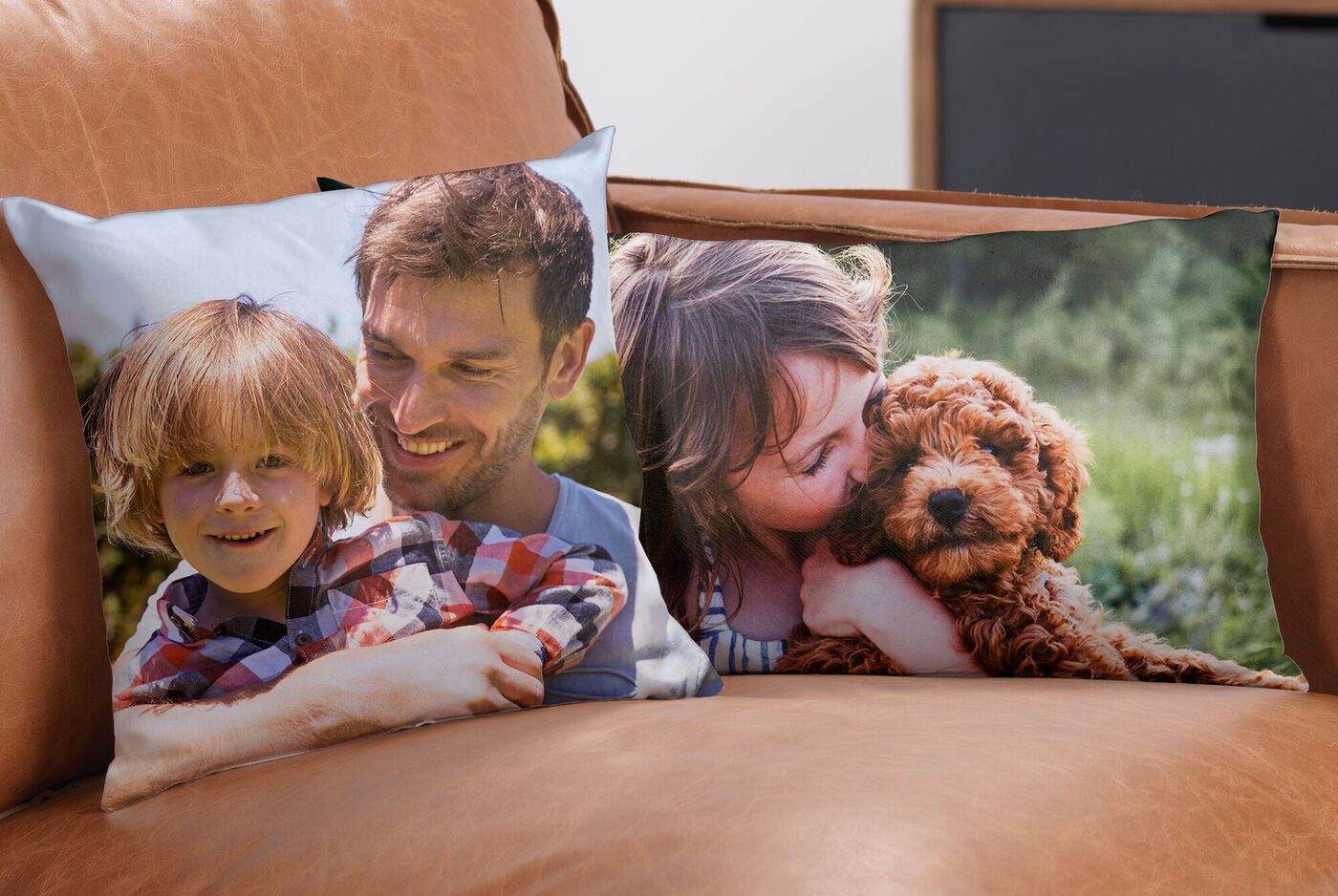 Zwei Kissen auf einer Couch zeigen fröhliche Momente mit Kindern und einem Hund.