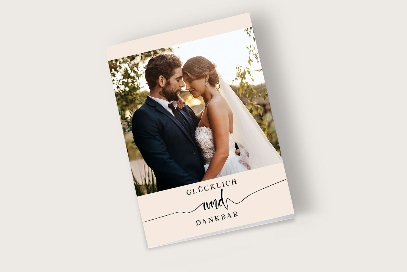 Ein wunderschönes CEWE Fotobuch mit einem romantischen Cover und den Worten 'GLÜCKLICH und DANKBAR'.