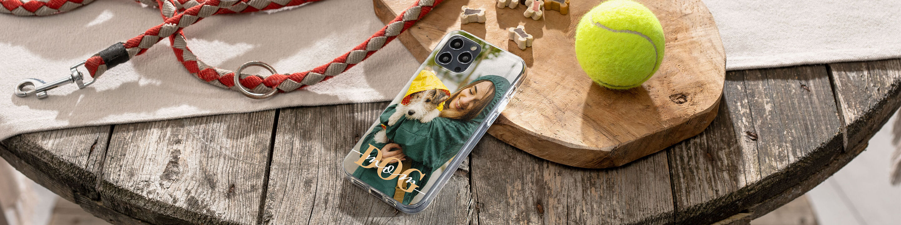 Ein einzigartiges Handycover mit einem Foto von einem Hund und einer Frau, das auf einem Holztisch liegt