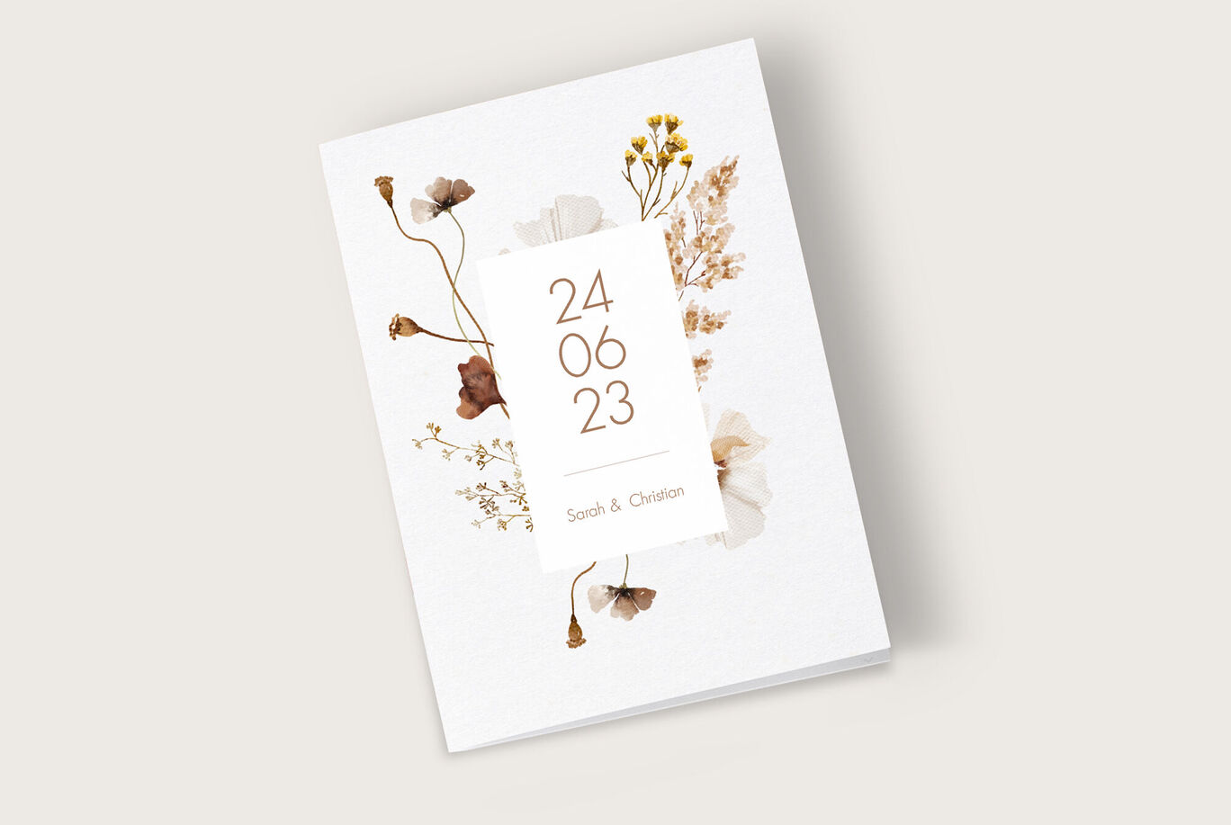 Ein elegantes Einladungskarten-Design in Weiß mit getrockneten Blumen und einem goldenen Datum.