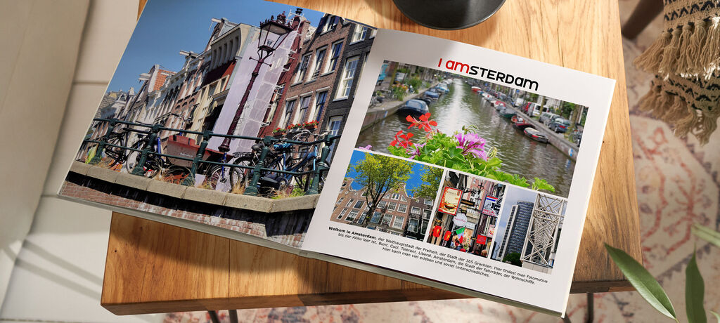 Ein aufgeschlagenes CEWE FOTOBUCH zeigt farbenfrohe Bilder aus Amsterdam, darunter Kanäle und Blumen.