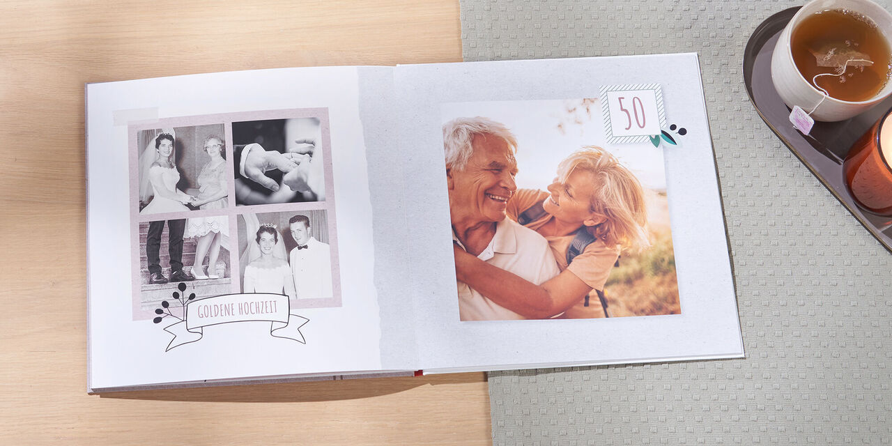 Ein offenes Fotobuch mit Erinnerungen und einem liebevollen Bild zum 50. Geburtstag.