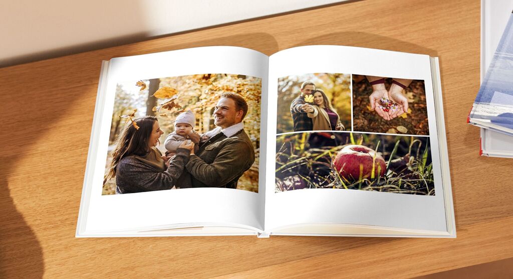 Familie genießt den Herbst, während sie Fotos im CEWE FOTOBUCH anschauen