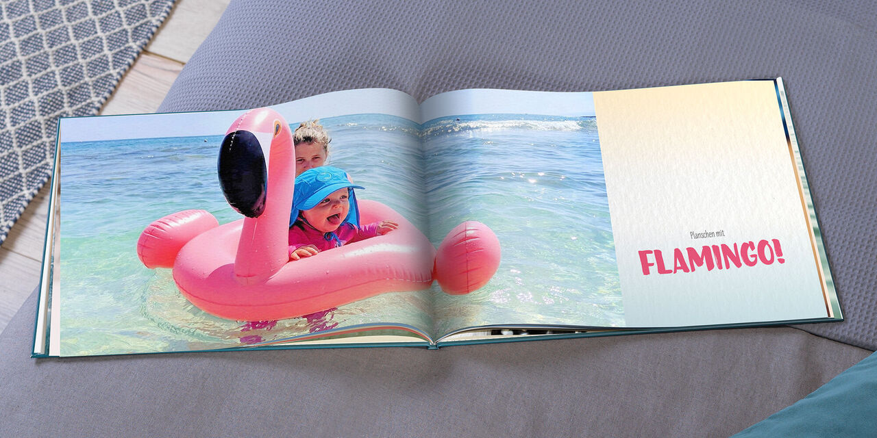 Ein fröhliches Kind schwimmt auf einem rosa Flamingo im Wasser