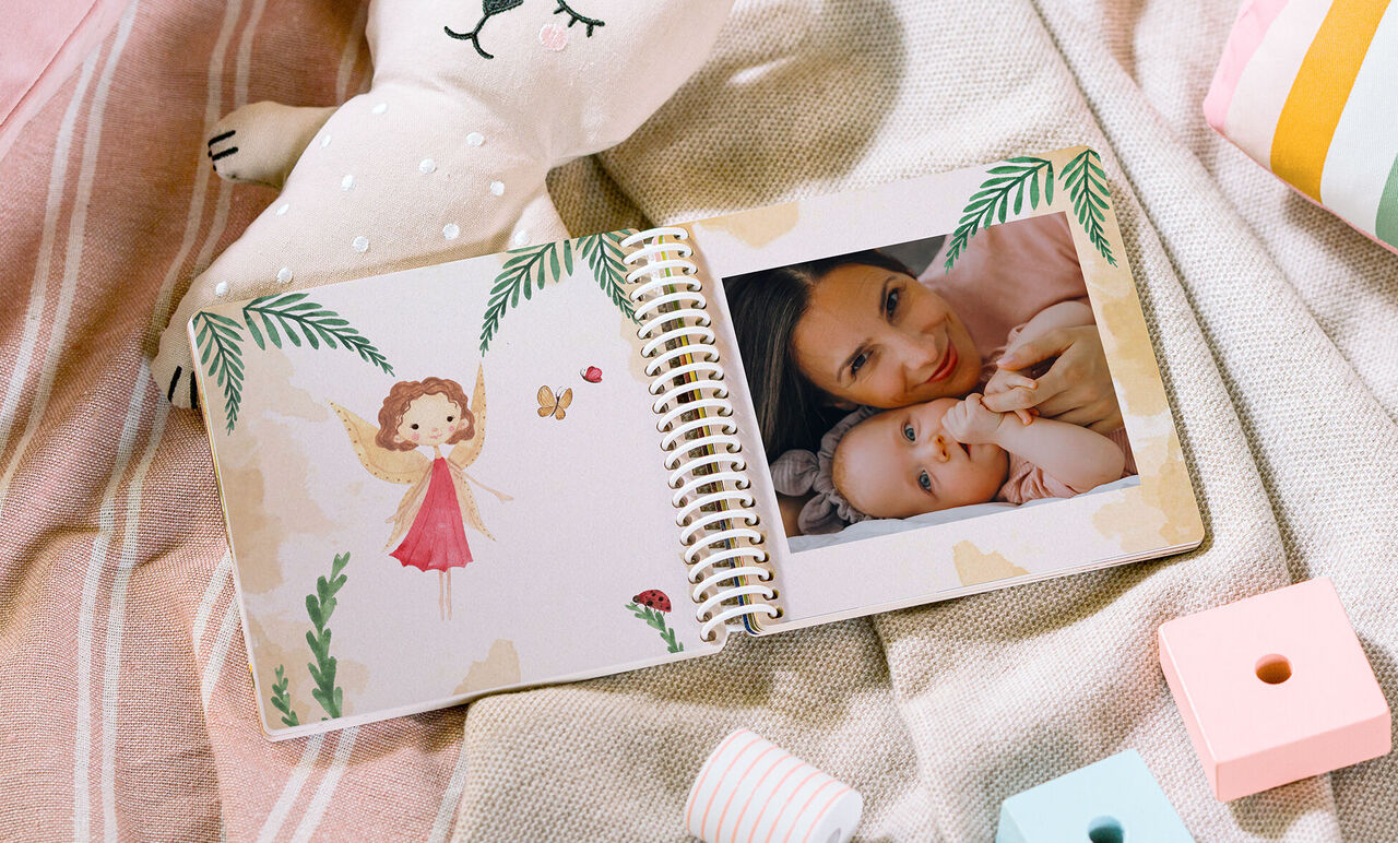 Offenes CEWE FOTOBUCH mit Spiralbindung, Illustration und Foto von Mutter mit Baby
