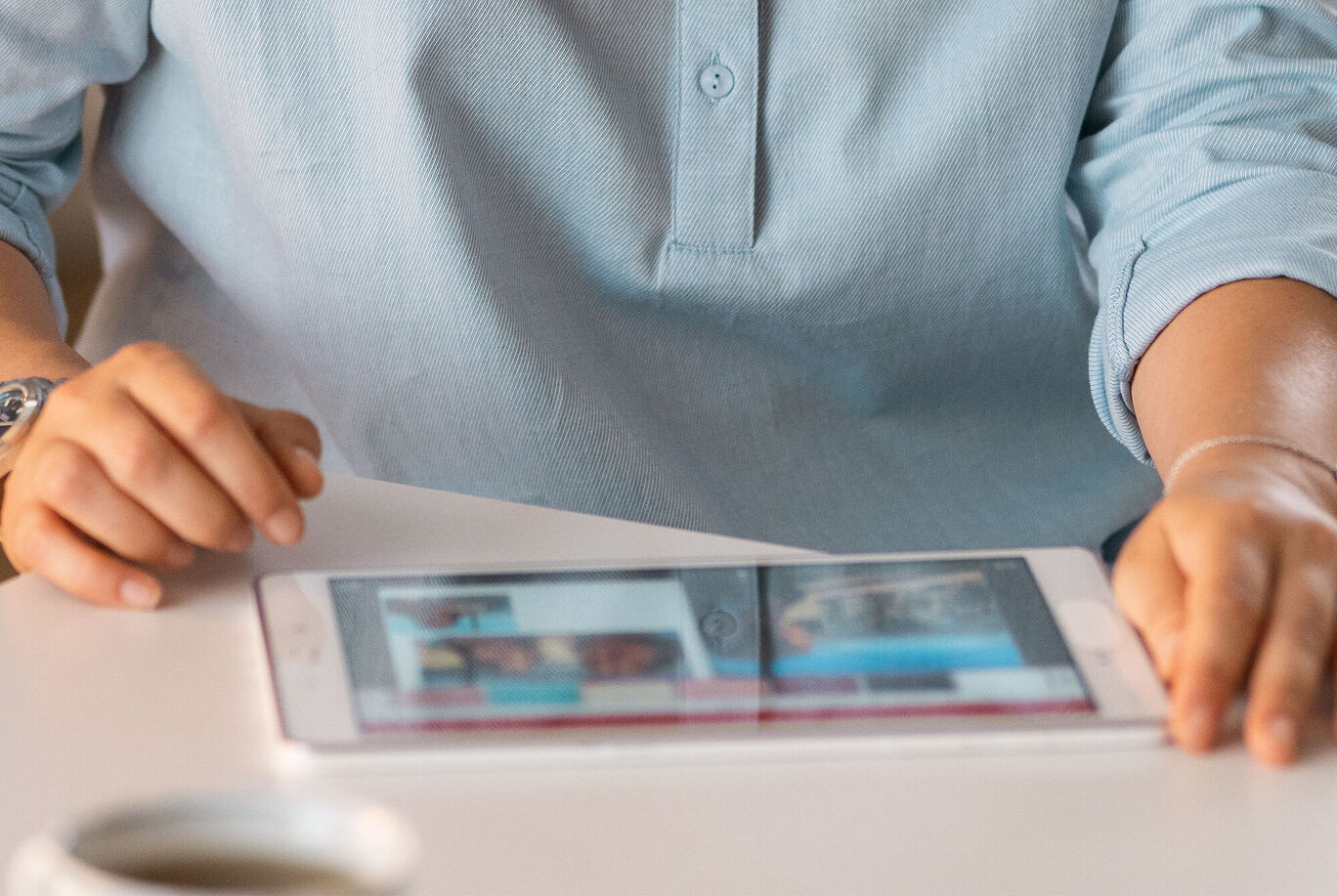 Eine Person schaut auf ein Tablet mit Bildern