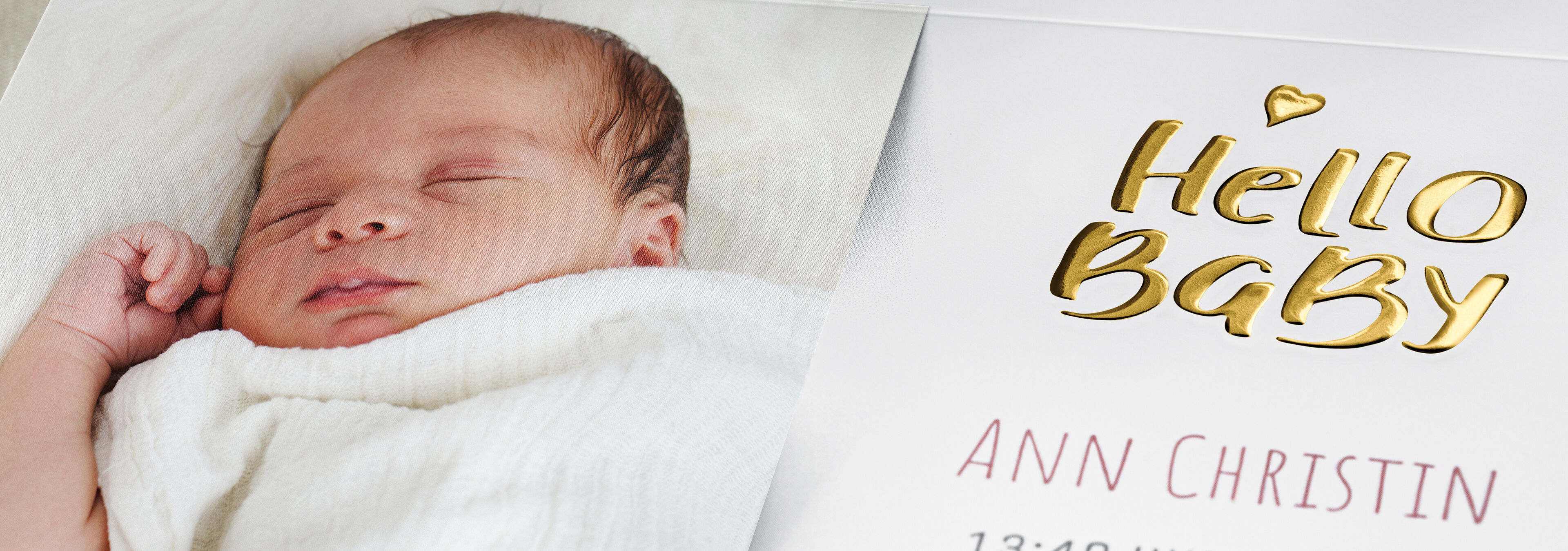 Ein Baby liegt in einer Decke, umgeben von einem liebevollen Design mit dem Text 'Hello Baby' und dem Namen Ann Christin.