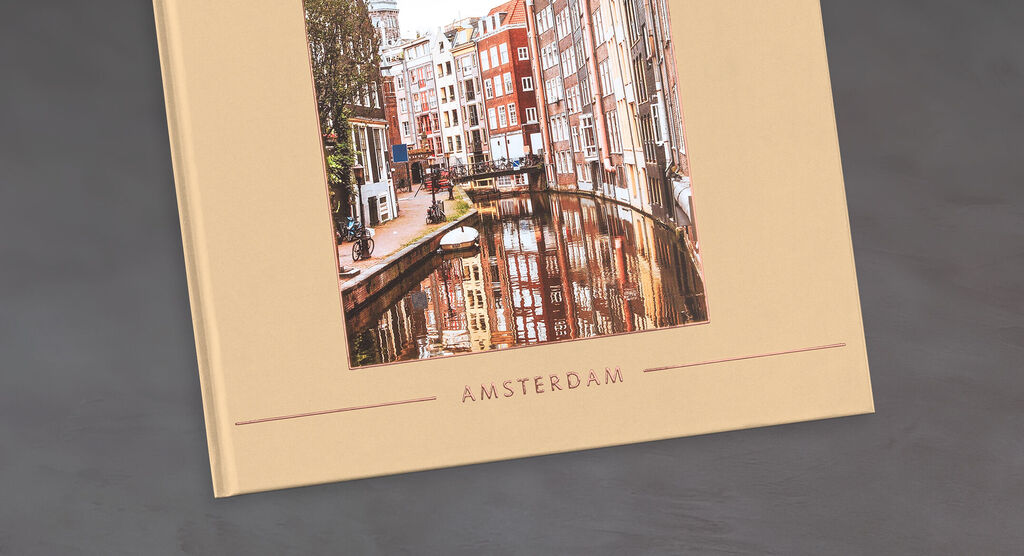 Ein CEWE Fotobuch mit einem Bild von Amsterdams grauen Straßen und Kanälen.