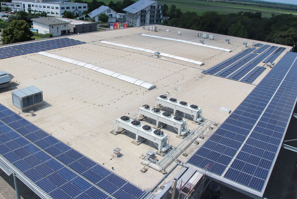 Dach mit Solarpanelen und Klimaanlagen auf einem modernen Gebäude