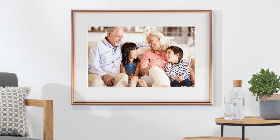 Eine Familie genießt eine liebevolle Umarmung auf dem Sofa. Sie strahlen Glück und Zusammenhalt aus. Die Szene zeigt, wie sie schöne Erinnerungen miteinander teilen.