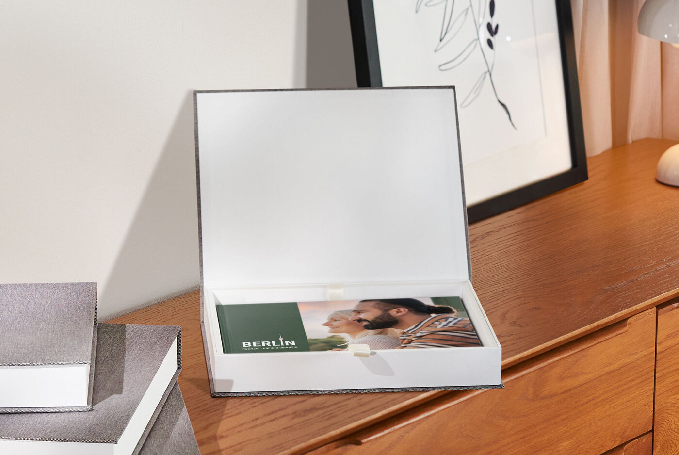 Schönes CEWE Fotobuch in einer offenen Geschenkbox auf einem Holztisch
