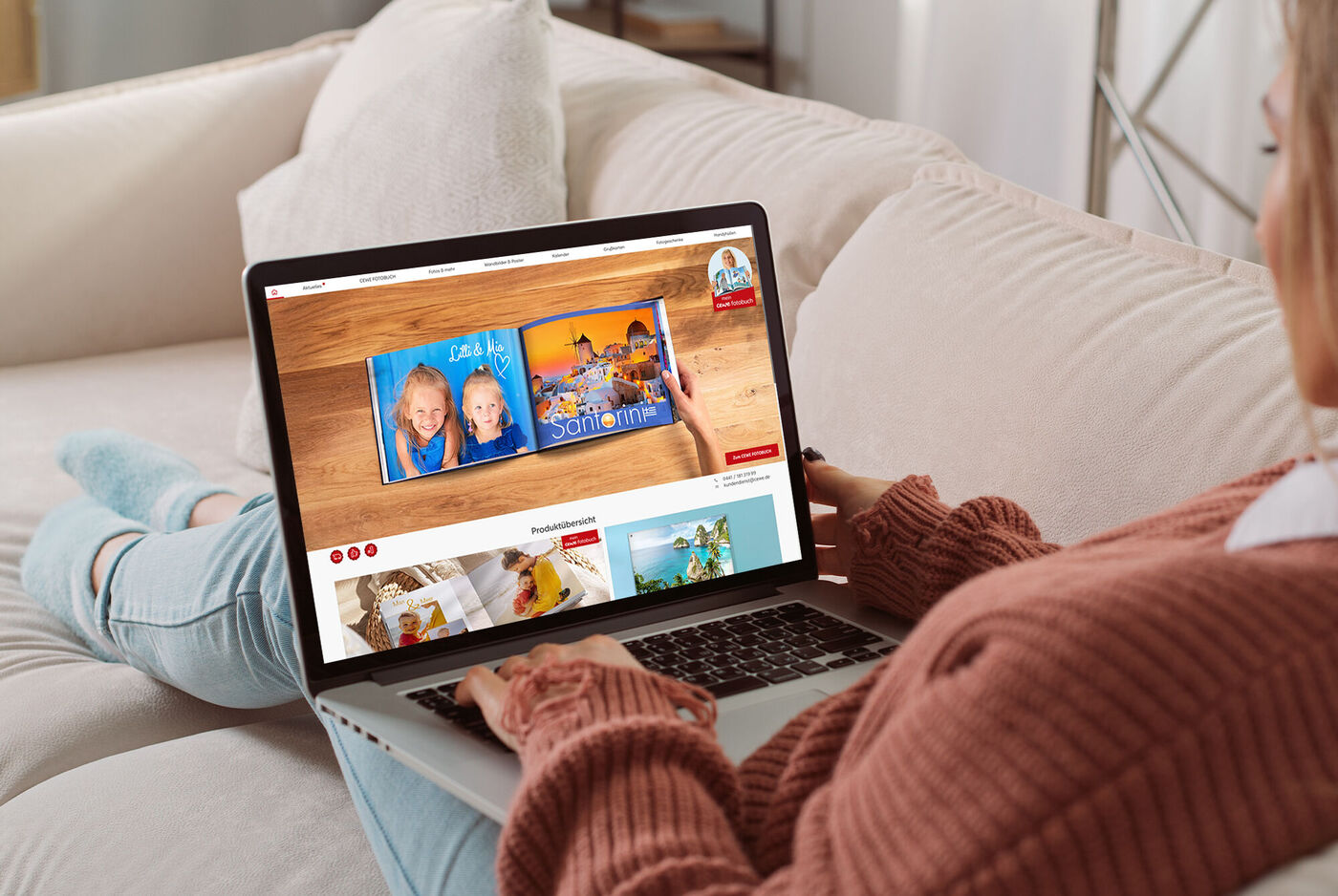 Eine Person sitzt entspannt auf dem Sofa mit einem Laptop, auf dem kreative Fotobücher von CEWE angezeigt werden, um Erinnerungen zu teilen und zu gestalten