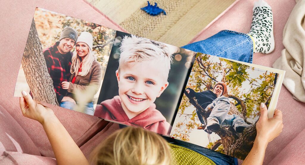 Eine Person blättert durch ein CEWE FOTOBUCH mit schönen Erinnerungen.