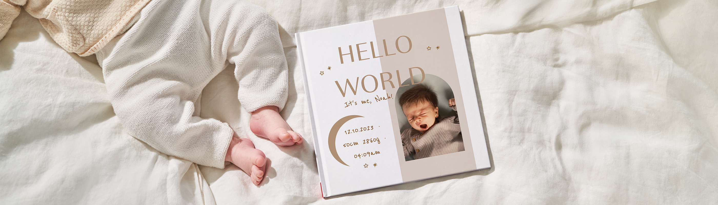 Babyfüße in weißem Strampler neben CEWE FOTOBUCH zur Geburt mit Foto und Geburtsdaten