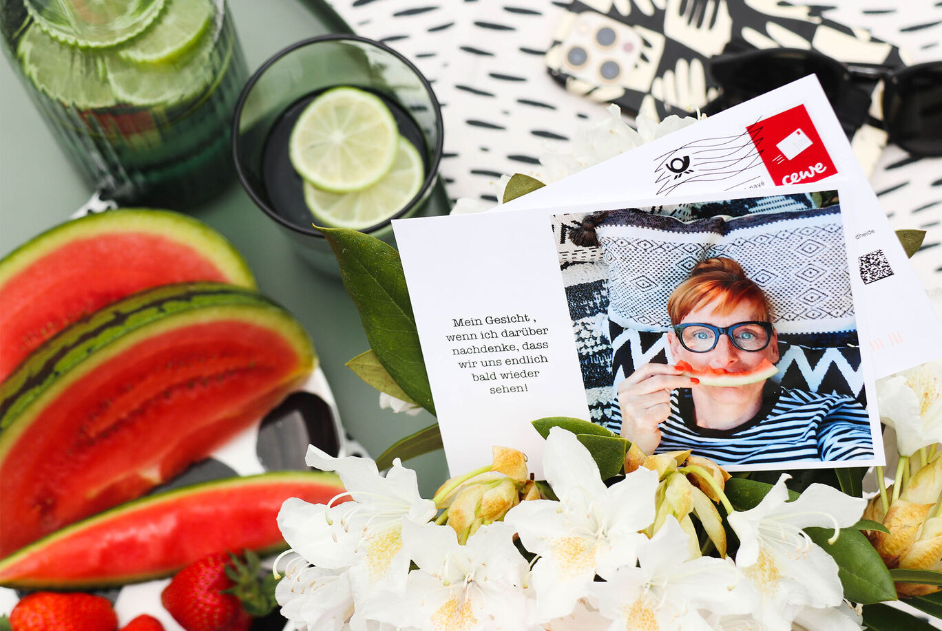 Eine kreative Sommeraufnahme mit Wassermelonen, Blumen und Getränken, die Freude und Entspannung ausstrahlen