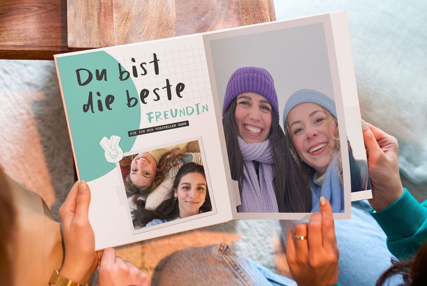 Zwei Frauen blättern in einem CEWE FOTOBUCH mit der Aufschrift "Du bist die beste Freundin"