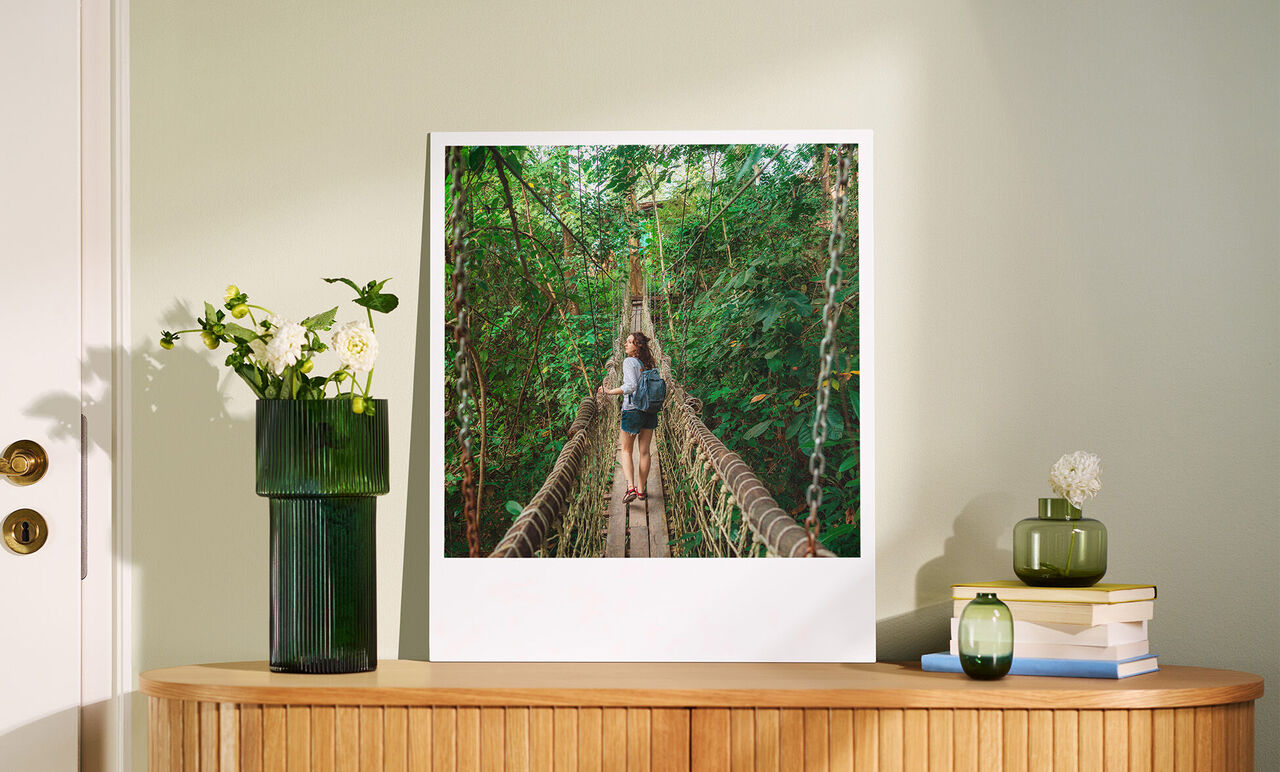Zwei Personen genießen einen Spaziergang über eine Hängebrücke in einem grünen Wald.