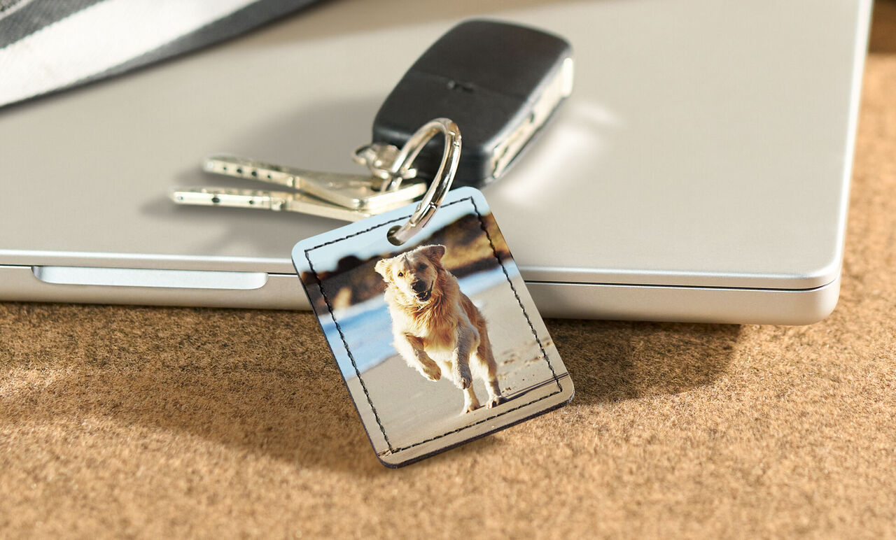 Ein Schlüsselanhänger mit einem Foto eines laufenden Hundes am Strand