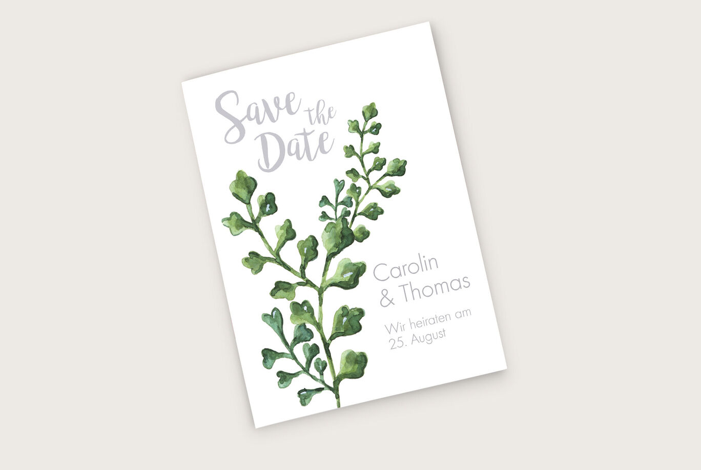 Ein liebevolles Save-the-Date-Kärtchen mit grünen Pflanzenmotiven. Der Text informiert über die Hochzeit von Carolin und Thomas.