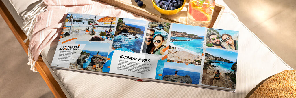 Ein offenes Fotobuch mit Reiseerinnerungen am Strand, umgeben von frischen Beeren und einer Holzplatte
