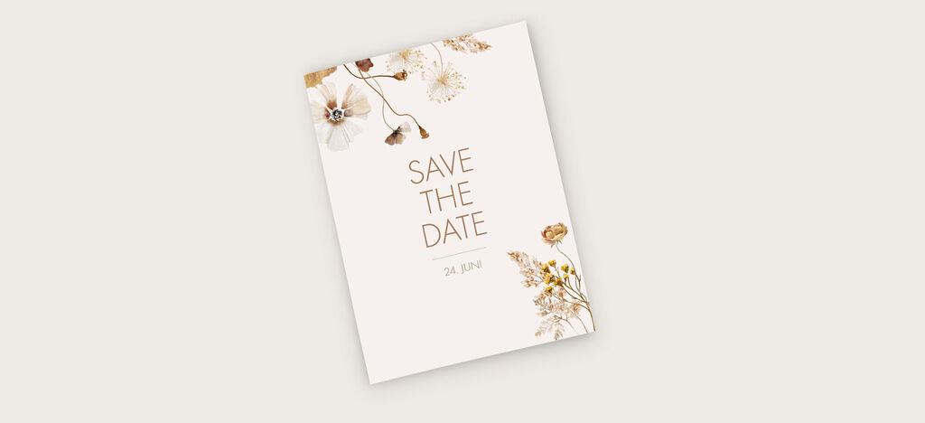 Elegante Save-the-Date-Karte mit floralen Motiven in sanften Farben.