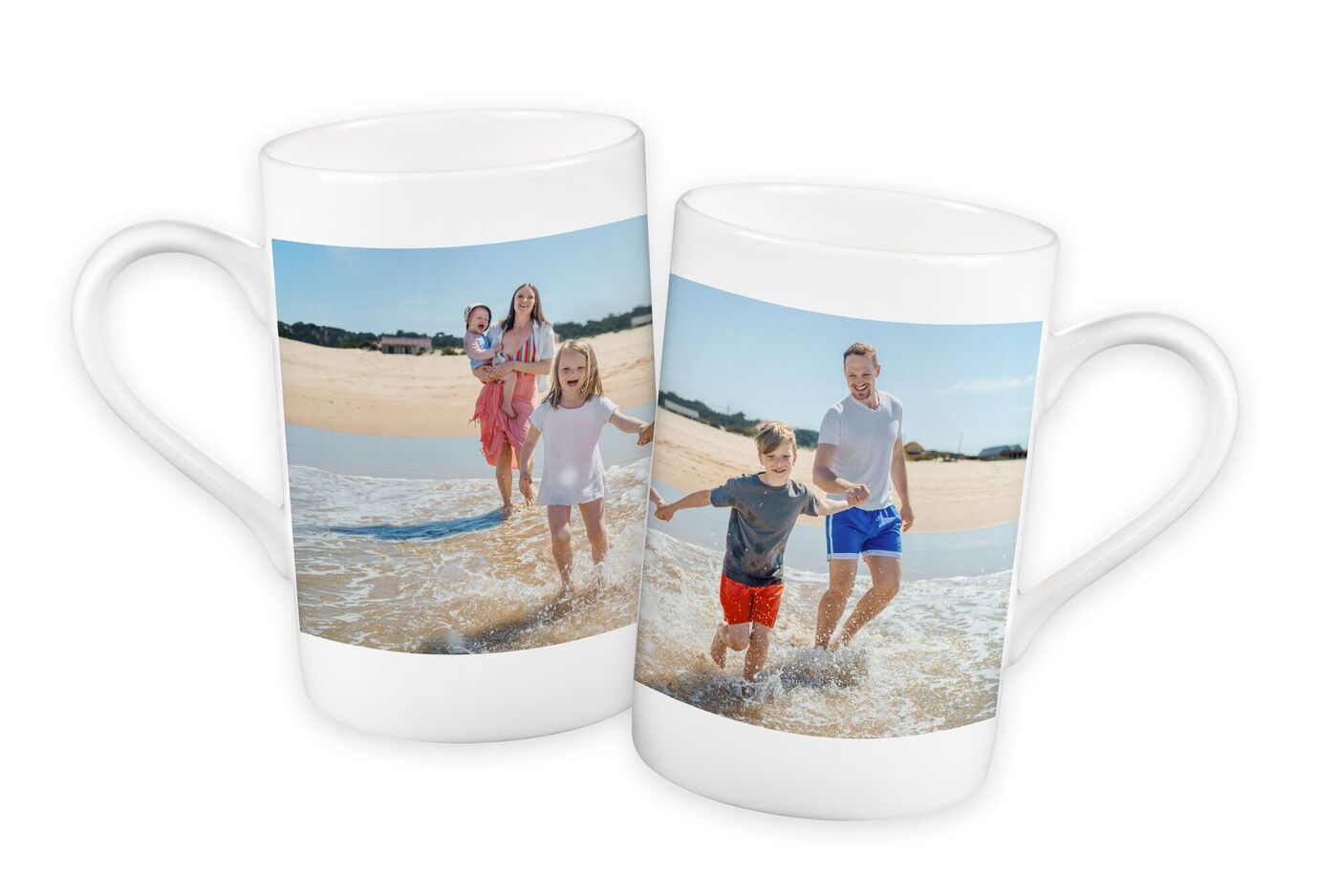 Zwei weiße Tassen mit Familienfotos am Strand. Eine Familie spielt am Wasser.