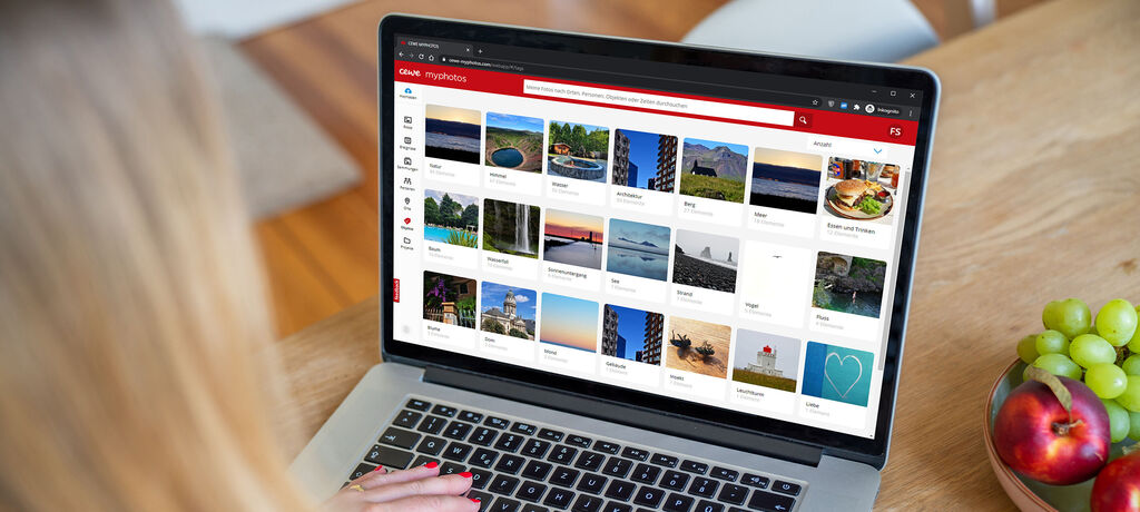 Person nutzt einen Laptop, um Fotos in der CEWE Fotowelt zu gestalten