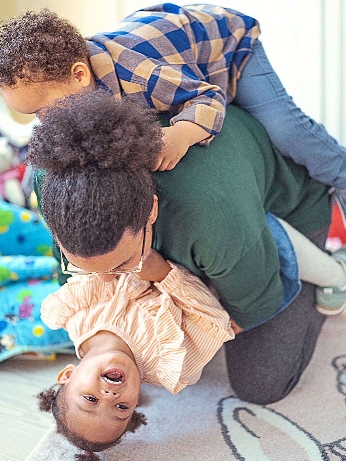 Ein fröhlicher Moment, wo eine Person mit zwei Kindern spielt und lacht