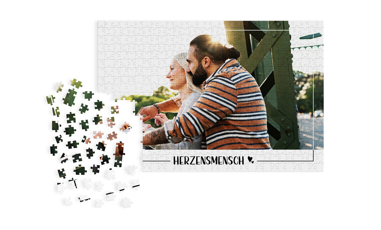 Puzzle mit einem positiven Motiv von zwei Menschen, ein Herz-Motiv darunter