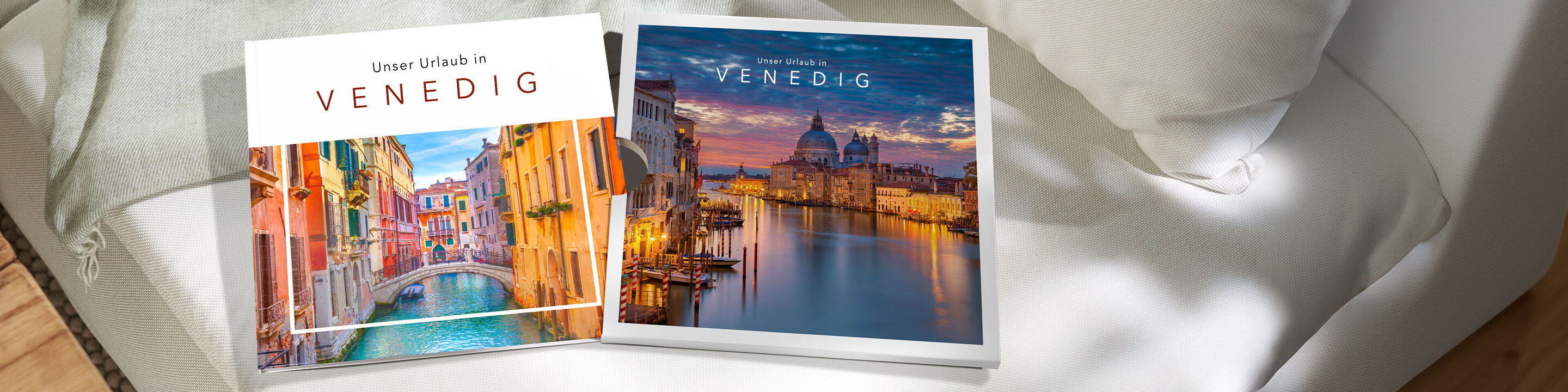 Zwei CEWE FOTOBUCH Exemplare mit Venedig-Fotos liegen auf einem hellen Sofa