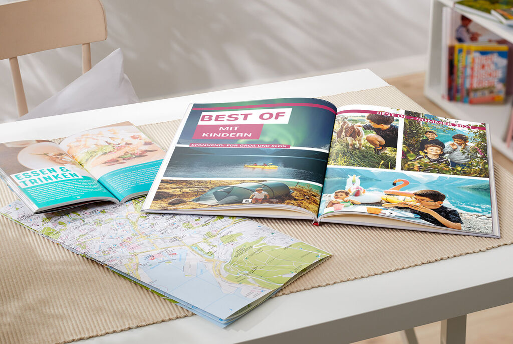 Offene Fotobücher und eine Landkarte auf einem Tisch