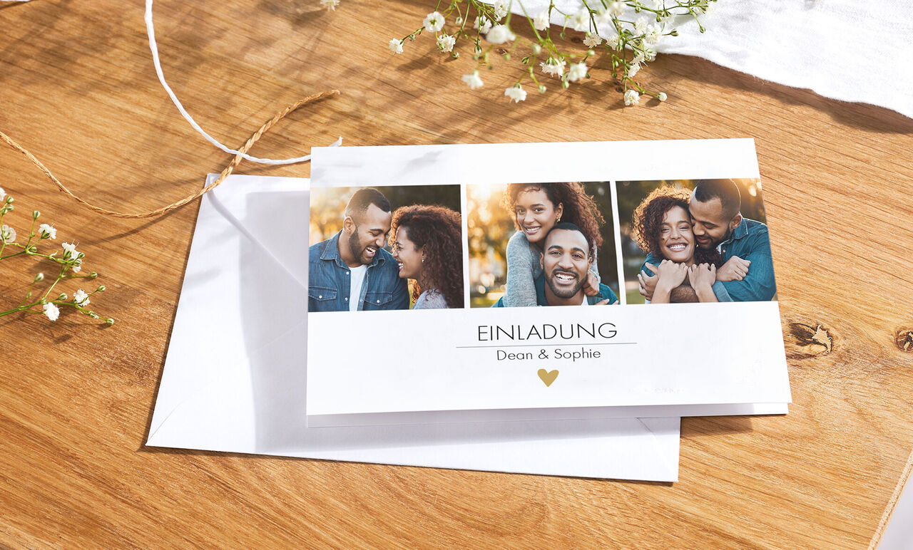 Einladungskarte mit Fotos von Dean und Sophie, umgeben von Blumen auf einem Holztisch