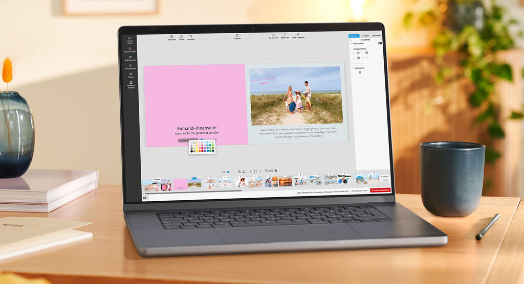 Ein Laptop steht auf einem Tisch. Auf dem Screen ist zu sehen, wie die Farbe für die Einband-Innenseite ausgewählt wird.