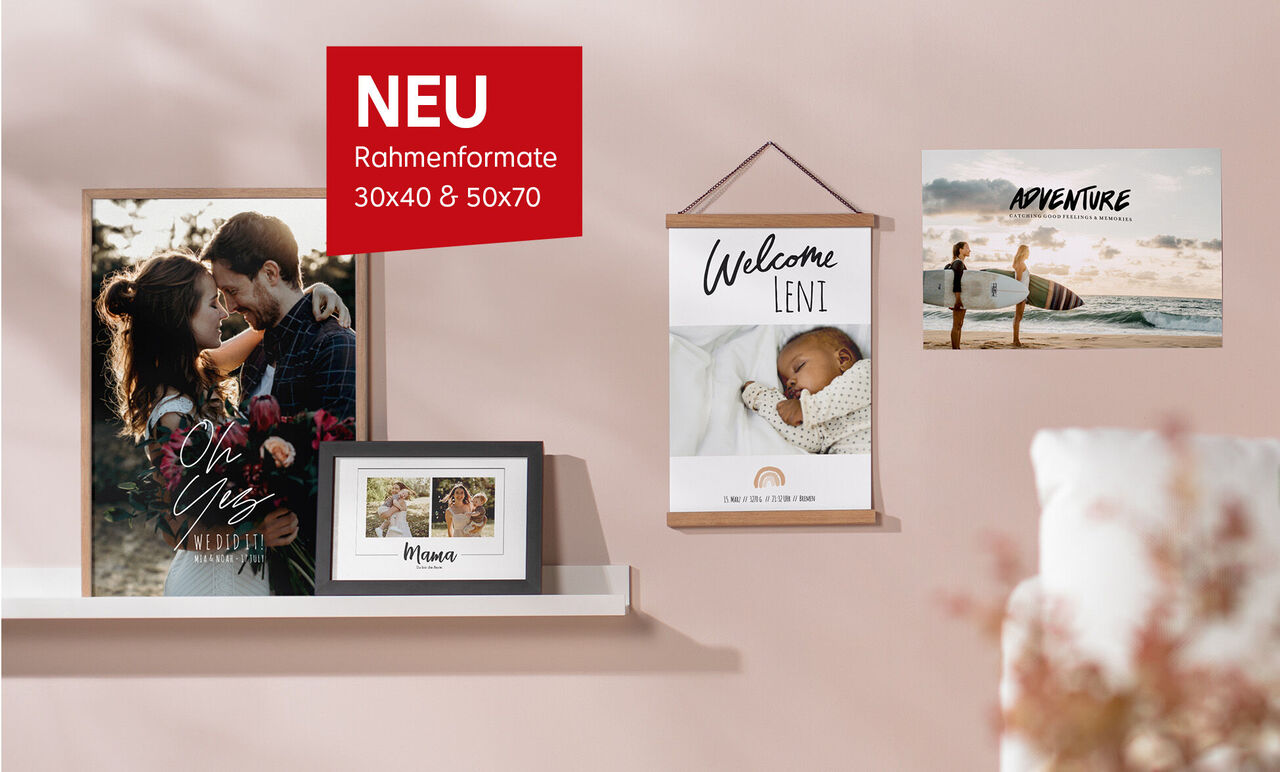 CEWE Wandbilder und gerahmte Fotos auf rosa Wand, darunter ein Paarfoto, ein Babyfoto mit 'Welcome Leni' sowie ein Strandmotiv